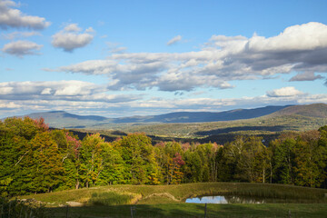 Obraz premium Scenic Mountain Valley with Pond and Rolling Hills