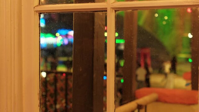 View from inside cozy cabin of christmas lights and people walking aesthetic blur