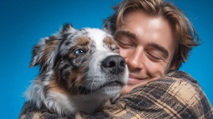 Young man hugging an Australian Shepherd dog