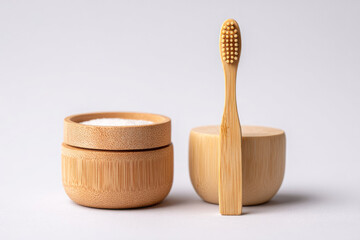Bamboo toothbrush and two natural containers with white powder, showcasing eco-friendly dental care products with minimalistic design and sustainable materials for a healthy lifestyle