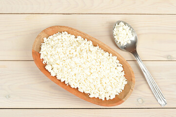 crumbly cottage cheese in a wooden plate