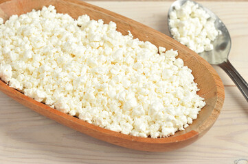 crumbly cottage cheese in a wooden plate