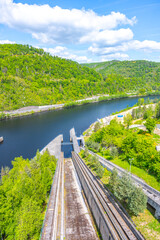 Fototapeta premium The boat lift at Orlik Dam, located in Czechia, efficiently transports vessels between water levels. Its scenic surroundings include lush greenery and a serene river landscape.