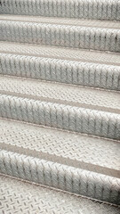 Close-up of industrial metal stairs with diamond plate anti-slip pattern in a modern urban setting