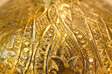 Extreme macro of floral embossed patterns on luxurious golden metal