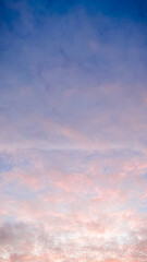 Dramatic sunset sky with textured clouds glowing in pink and orange colors during evening twilight