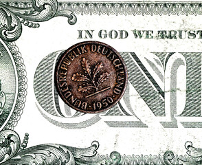 A close-up of a German coin against a dollar bill
Money of Germany and America