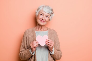 Elderly Woman Holding Heart Symbol Love and Kindness Concept