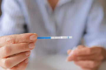 Rapid test strip in hand, respiratory virus screening, influenza, COVID-19, pneumonia, epidemic, healthcare diagnostics, infection control, home self test, copy space