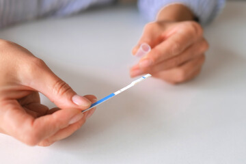 Rapid test strip in hand, respiratory virus screening, influenza, COVID-19, pneumonia, epidemic, healthcare diagnostics, infection control, home self test, copy space