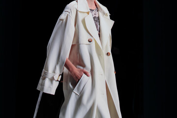 Fashion classy details of long white coat, fancy cloth on black background