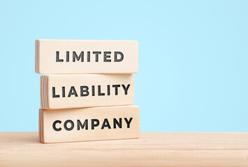 Limited liability company concept with wooden blocks on blue background