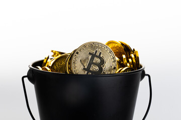 Bucket filled with golden bitcoin coins on white background. © Midea 