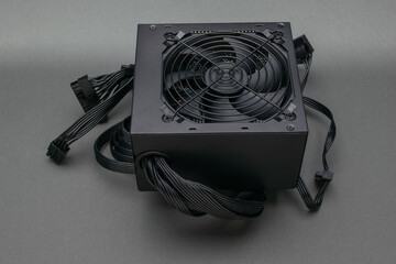 Desktop Computer Power Supply Unit with Cooling Fan and Modular Cables on Gray Background