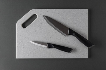 Sleek Black Knives on White Cutting Board - Modern Kitchen Essentials