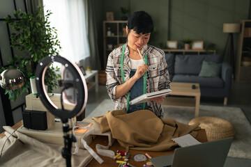Woman creating online sewing tutorial video at home