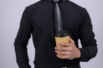 Close-up of a man in a black shirt holding a coffee cup.