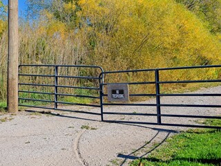 Farm gate posted No Trespassing aon dirt road
