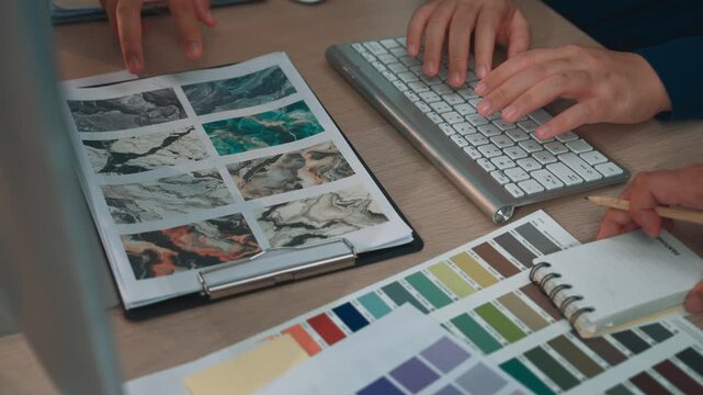 A designer selects color palettes and textures from various swatches in their workspace, showcasing creativity and artistic inspiration in modern design processes. SACTR