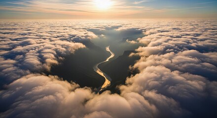 Aerial view of a winding river through clouds at sunrise  