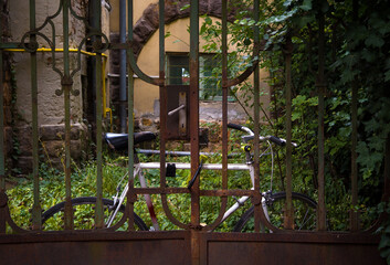 Bicycle chained behind rusty gate