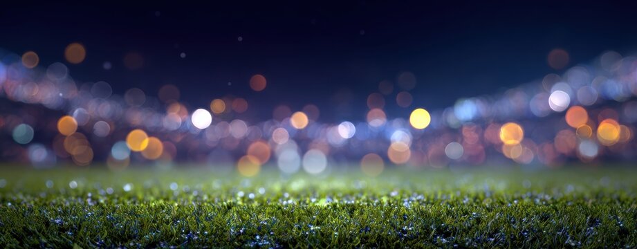 empty grass field in a soccer stadium at night