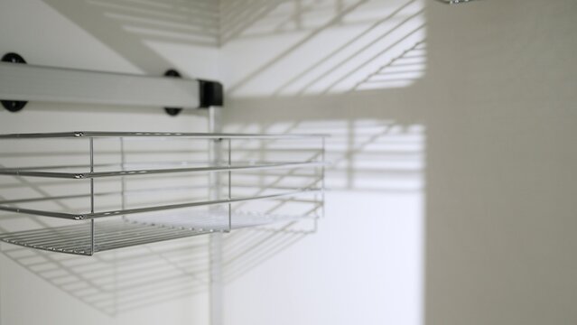 Pull-out wire basket shelving system in cabinet