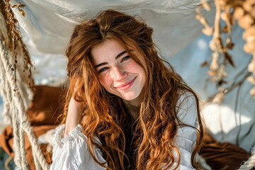 Young woman enjoys a sunny day outdoors while sitting among soft fabrics and natural elements in her surroundings
