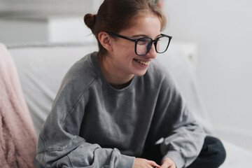 Happy, Laughing Girl In Glasses On The Sofa In A Light Room