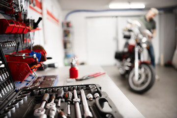 Man With Classic Motorcycle In Garage Checking And Servicing Motorcycle Regularly
