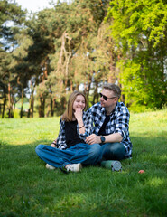 Happy Father And Daughter Enjoy Spending Time Together Sitting On Grass In The Park