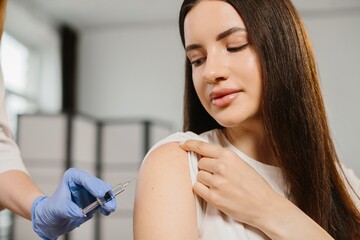 Young woman receiving flu shot vaccination in arm © dsheremeta
