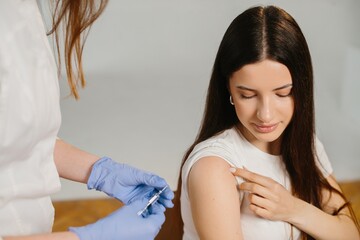Woman getting vaccine shot from medical professional © dsheremeta