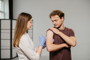 Fototapeta premium Healthcare worker administering vaccine to young man's arm