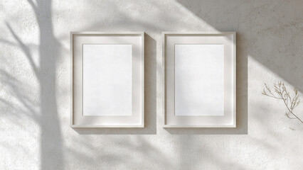 Sunlit interior wall mockup with two vertical white frames, clean textured plaster wall, bright natural light, minimalist wall art presentation for poster and print set designs