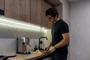 Man slicing salami on cutting board in modern minimalist kitchen