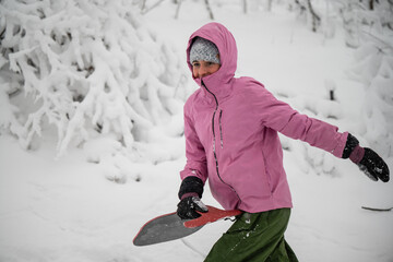 Woman enjoying winter fun carrying sled in snow