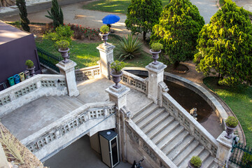 Escadaria cl&aacute;ssica em edif&iacute;cio hist&oacute;rico com jardins e arquitetura ornamenta