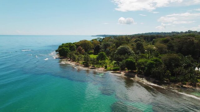 Costa Rica coastline with dense green forest under bright sunny skies