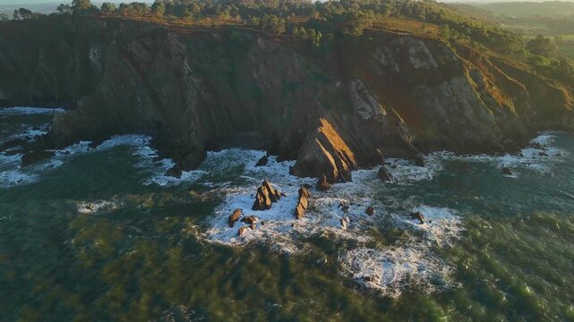 Rocky coastline and ocean at sunset, Playa de Moniello, Spain