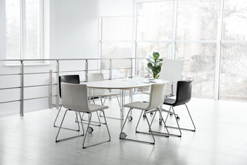 Fototapeta premium Stylish chairs, table and houseplant in office. Interior design