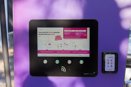 Close-up of the control panel and touchscreen of an Enel Way electric vehicle charging station, showing payment instructions and user interface for EV charging in Italy.