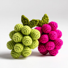 Fototapeta premium Charming handcrafted crochet grapes in vibrant pink and green hues, showcasing a playful and artistic food representation.