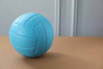 One volleyball ball on brown table, space for text