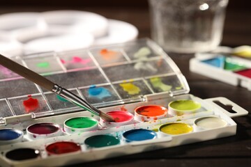 Obraz premium Painting with brush and watercolor at wooden table, closeup