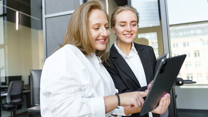 Two women using a tablet in an office space