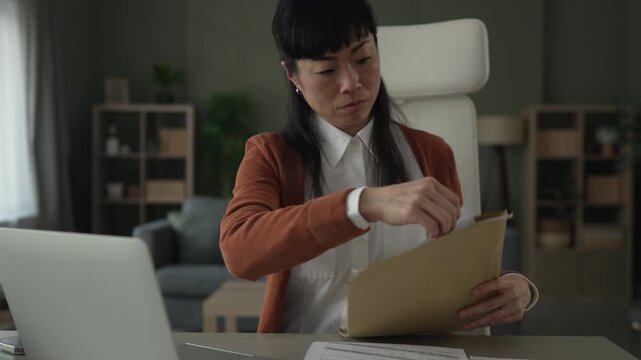 Businesswoman opening folder and checking documents