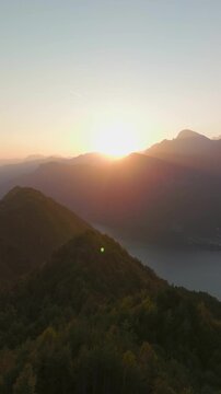 Aerial landscape view of lake and mountains at sunset from Grande Panchina, Capovalle, Italy, vertical video