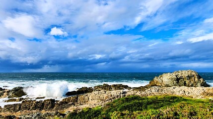 Dramatic ocean waves crashing on rocky coastline with stormy sky