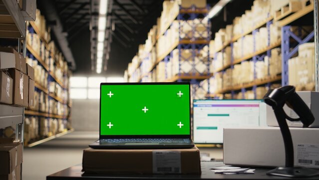 Empty stock room with isolated copy space monitor on workstation, prepared for digital interface mockups. Logistics center environment includes huge packages on shelves or racks. - Powered by Adobe